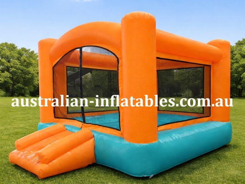 Orange and teal inflatable bounce house on a grassy field in a park